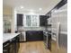 Bright kitchen with stainless steel appliances, black cabinets, hardwood floors, granite countertops, and a sink with a view at 315 Allister Dr, Raleigh, NC 27609