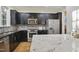 Stylish kitchen featuring stainless steel appliances, granite countertops, black cabinetry, and hardwood floors at 315 Allister Dr, Raleigh, NC 27609