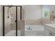 Clean bathroom featuring a tiled shower, a soaking tub, and natural lighting at 317 Striped Maple Ct, Apex, NC 27539