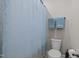 Bathroom with a toilet, shower with curtain, tile flooring, and neutral paint at 317 Striped Maple Ct, Apex, NC 27539