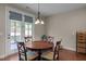 Dining area features a wooden table, seating for four, hardwood floors, and sliding door access to the porch at 317 Striped Maple Ct, Apex, NC 27539