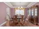 Open dining room with hardwood floors, decorative molding, and a large window at 317 Striped Maple Ct, Apex, NC 27539