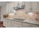Kitchen featuring white cabinets, granite countertops, stainless steel appliances, and a tile backsplash at 317 Striped Maple Ct, Apex, NC 27539