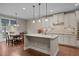 Island kitchen features pendant lighting, granite countertops, stainless steel appliances, and hardwood floors at 317 Striped Maple Ct, Apex, NC 27539