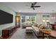 Cozy living room featuring plush seating, hardwood floors, a wall-mounted TV, and backyard view at 317 Striped Maple Ct, Apex, NC 27539