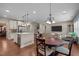 Open-concept kitchen and dining area with hardwood floors, view of the living room and staircase at 317 Striped Maple Ct, Apex, NC 27539