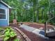 Lush backyard featuring a stone pathway, fire pit, and seating area, ideal for entertaining at 3400 Appling Way, Durham, NC 27703