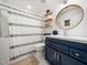 Bright bathroom with modern vanity, decorative shelving, and a stylish shower curtain at 3400 Appling Way, Durham, NC 27703