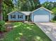 Charming blue home featuring a well-manicured lawn and an attached two-car garage at 3400 Appling Way, Durham, NC 27703