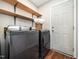 Modern laundry room with wood floors and shelving for storage at 3400 Appling Way, Durham, NC 27703