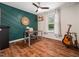 Modern home office with a green accent wall, wood floors, and an acoustic guitar at 3400 Appling Way, Durham, NC 27703