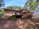 Backyard featuring a deck with stairs, a brick facade, and lots of trees at 3721 Suffolk St, Durham, NC 27707