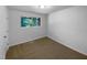 Bright bedroom with neutral carpet, paint, and a window offering serene outdoor views at 3721 Suffolk St, Durham, NC 27707
