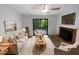 Bright, staged living room featuring a fireplace, ceiling fan, and sliding glass doors to the outdoor deck at 3721 Suffolk St, Durham, NC 27707