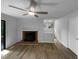 View of the living room showcases wood-look floors, a brick fireplace, and access to the outdoor deck at 3721 Suffolk St, Durham, NC 27707