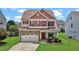 Charming two-story home featuring a stone facade, red shutters and a well-manicured lawn at 40 Horizon Trl, Garner, NC 27529