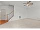 A spacious living room with plush carpeting, ceiling fan, and a staircase to the second floor at 40 Horizon Trl, Garner, NC 27529