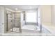 Bathroom featuring tile flooring, standalone tub, and large glass shower at 405 Falls Bluff Dr, Wake Forest, NC 27596