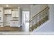 Hallway showcasing stairway and built-in kitchenette featuring bright cabinetry and dark countertops at 405 Falls Bluff Dr, Wake Forest, NC 27596