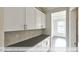 Convenient kitchenette features bright cabinetry, dark countertops, and easy access to the dining room at 405 Falls Bluff Dr, Wake Forest, NC 27596