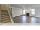 Spacious living room boasting a fireplace, hardwood floors, ample natural light, and staircase access at 405 Falls Bluff Dr, Wake Forest, NC 27596