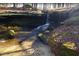A small waterfall surrounded by lush greenery, creating a peaceful nature scene at 405 Falls Bluff Dr, Wake Forest, NC 27596