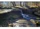 A serene waterfall flows over mossy rocks in a tranquil, natural setting at 405 Falls Bluff Dr, Wake Forest, NC 27596
