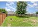 Well-maintained backyard featuring a spacious lawn, mature tree, and a wooden fence, creating a serene outdoor space at 4712 Rockport Dr, Durham, NC 27703