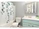 Bathroom with a tub/shower combo, blue vanity, decorative shower curtain, and modern fixtures at 4712 Rockport Dr, Durham, NC 27703