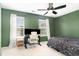Green bedroom with a workstation, ceiling fan, and carpeted floors at 4712 Rockport Dr, Durham, NC 27703