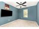 A comfortable bedroom featuring neutral carpeting, a ceiling fan and a large window at 4712 Rockport Dr, Durham, NC 27703