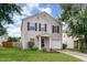 Traditional home featuring a manicured front lawn, mature trees, and attached garage at 4712 Rockport Dr, Durham, NC 27703