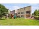 Home's back exterior with a large yard, playset, and screened porch on the second level at 5028 Blue Jack Oak Dr, Cary, NC 27519