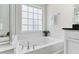 Bright bathroom featuring a tiled shower and soaking tub combination, with a window above the tub at 5028 Blue Jack Oak Dr, Cary, NC 27519