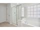 Bright bathroom featuring a tiled shower, soaking tub, and window bringing in natural light at 5028 Blue Jack Oak Dr, Cary, NC 27519
