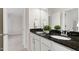 Bright bathroom featuring dual sinks, granite counters, and a mirror reflecting the bathroom and hallway at 5028 Blue Jack Oak Dr, Cary, NC 27519
