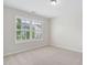 Bright bedroom featuring neutral walls, plush carpet, and one window with horizontal blinds at 5028 Blue Jack Oak Dr, Cary, NC 27519