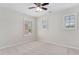 Bright bedroom with neutral walls, plush carpet, ceiling fan, and 3 windows with horizontal blinds at 5028 Blue Jack Oak Dr, Cary, NC 27519