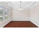 Dining room with a large window, hardwood floors, and an elegant chandelier at 5028 Blue Jack Oak Dr, Cary, NC 27519