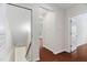 Hallway with wood floors and doors leading to other rooms with carpeted floors and painted walls at 5028 Blue Jack Oak Dr, Cary, NC 27519