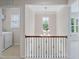 Upstairs hallway featuring laundry room, staircase, and view into another room at 5028 Blue Jack Oak Dr, Cary, NC 27519