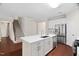 Open kitchen with stainless steel appliances, a white island, and stairs nearby at 5028 Blue Jack Oak Dr, Cary, NC 27519