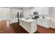 Modern kitchen featuring white cabinets, stainless steel appliances, and a spacious island at 5028 Blue Jack Oak Dr, Cary, NC 27519