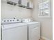 Bright laundry room features a side-by-side washer and dryer and a shelf for storage at 5028 Blue Jack Oak Dr, Cary, NC 27519