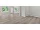 Open-concept living room with wood-look floors, a ceiling fan, and views of the backyard through multiple windows at 5028 Blue Jack Oak Dr, Cary, NC 27519