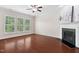 Bright living room featuring a fireplace, hardwood floors, and large windows with views of the surrounding greenery at 5028 Blue Jack Oak Dr, Cary, NC 27519