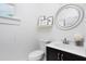 Bright half bathroom with white fixtures, dark vanity, and decorative art at 507 Rosengarten Aly, Raleigh, NC 27603