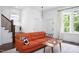 Cozy living room features hardwood floors, an orange sofa, lots of natural light, and easy access to the staircase at 507 Rosengarten Aly, Raleigh, NC 27603