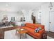 Bright living room with hardwood floors, neutral rug, and an orange sofa at 507 Rosengarten Aly, Raleigh, NC 27603
