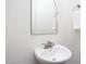 Clean powder room featuring a pedestal sink, mirror, and towel rack at 507 Rosengarten Aly, Raleigh, NC 27603